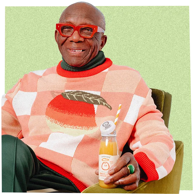 man wearing a big knitwear jumper and holding an innocent smoothie